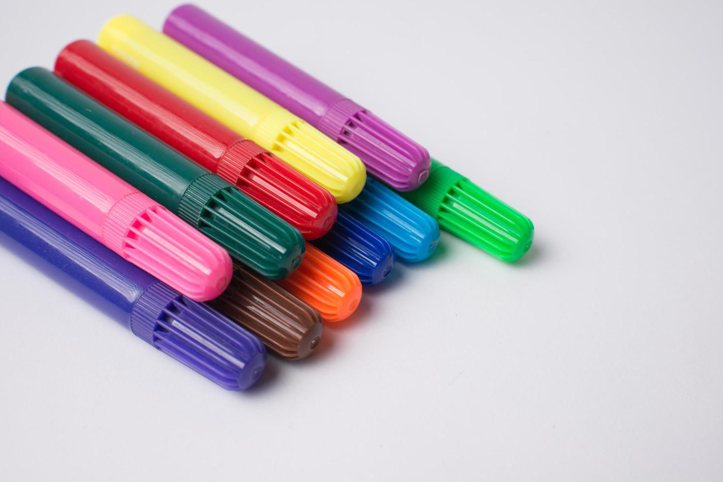 Pile of colorful markers on a white background photo