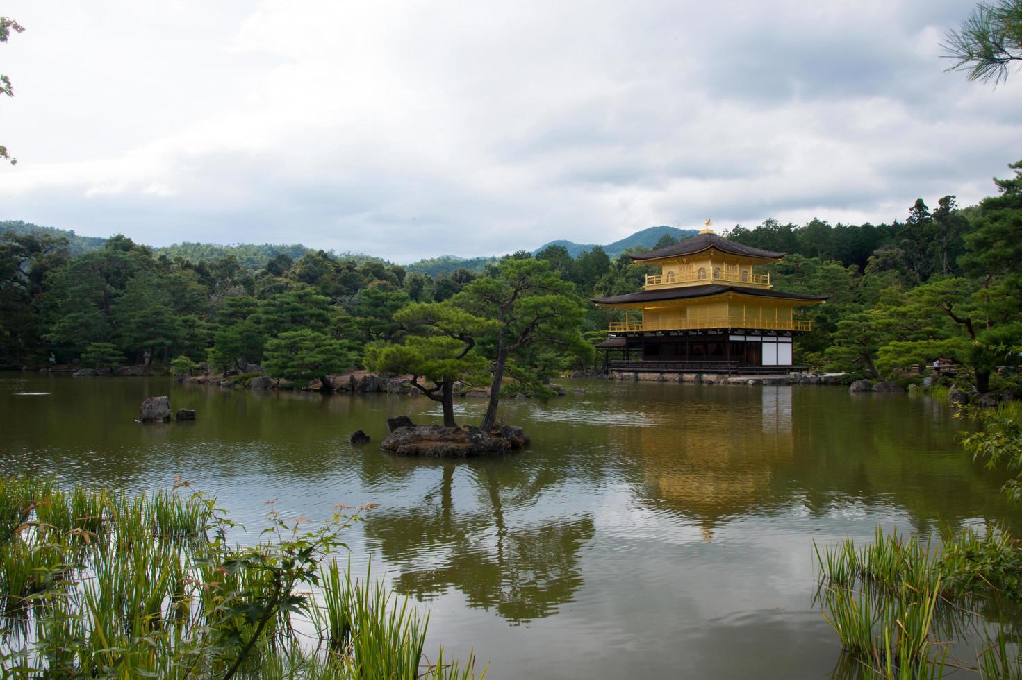 Beautiful view of Golden Temple and the lake and forest around it. Cloudy day, no people. Kyoto, Japan photo