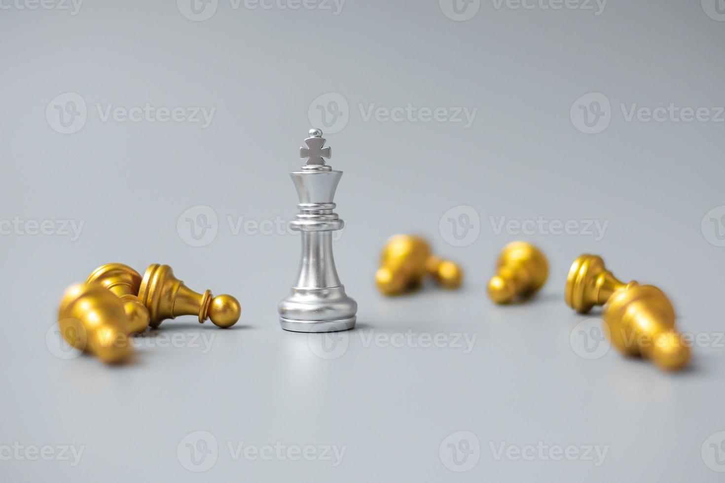 La figura plateada del rey del ajedrez se destaca entre la multitud de enemigos u oponentes. estrategia, éxito, gestión, planificación empresarial, disrupción, concepto de victoria y liderazgo foto