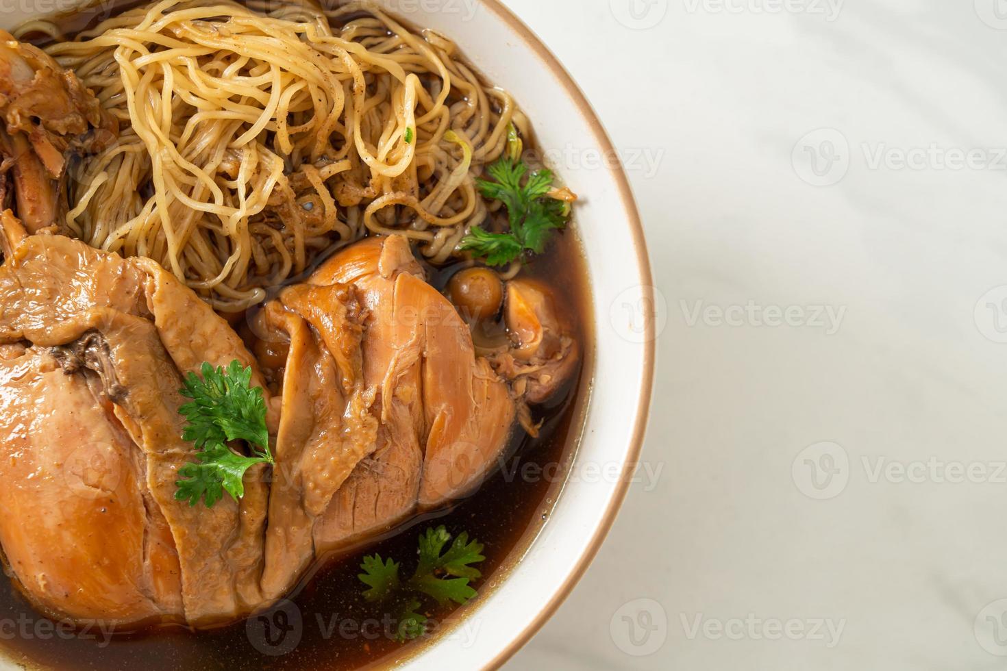 fideos con pollo a la brasa en sopa marrón foto