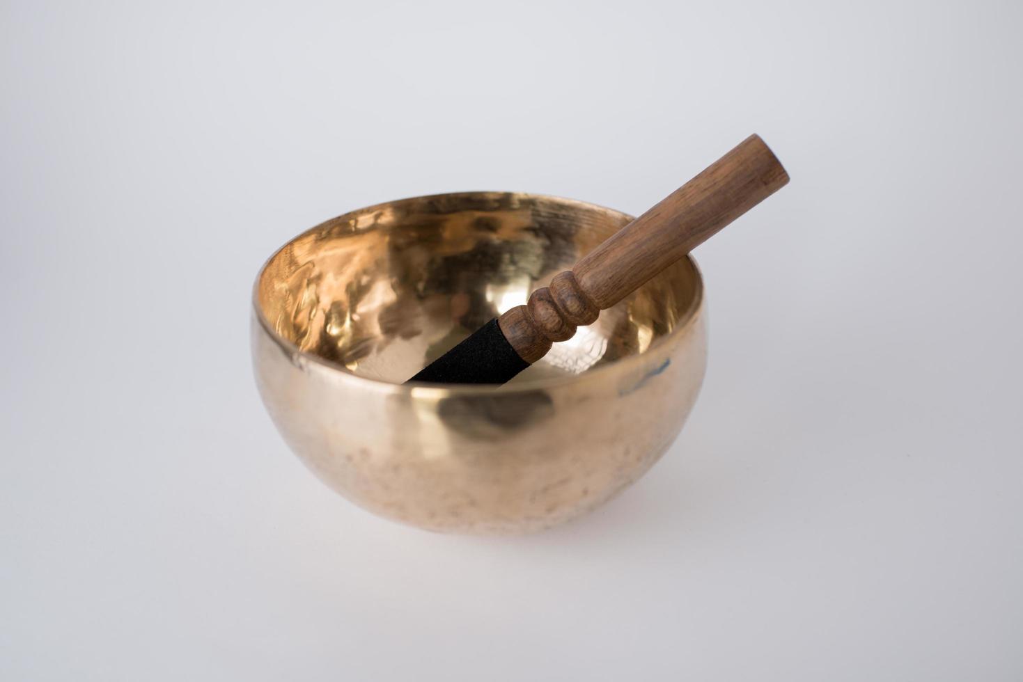 Tibetan Meditation Singing Bowl and wooden mallet with white background. Chakra healing photo