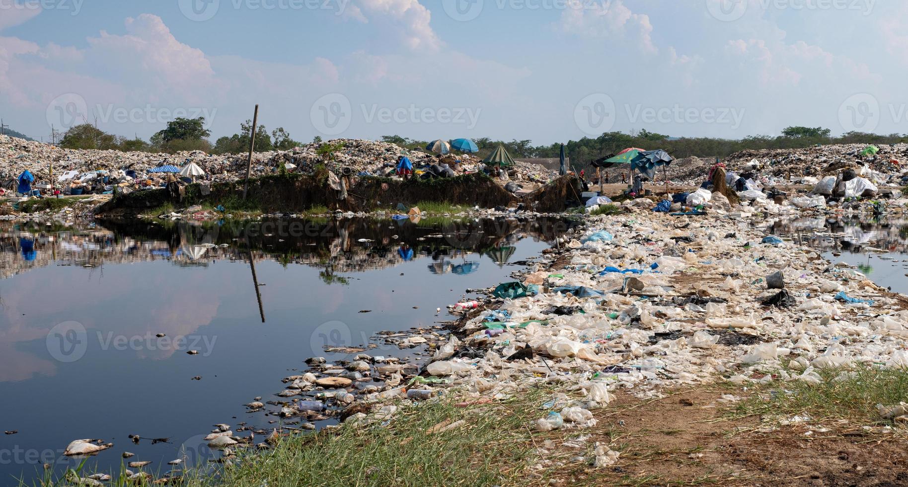 Polluted water and mountain large garbage pile and pollution, Pile of stink and toxic residue, These waste come from urban and industrial areas can not get rid of photo