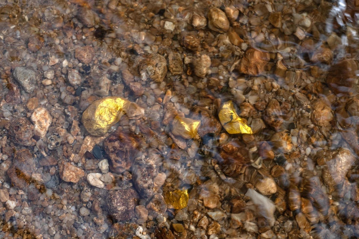 Pure gold nugget ore found in mine with natural water sources photo