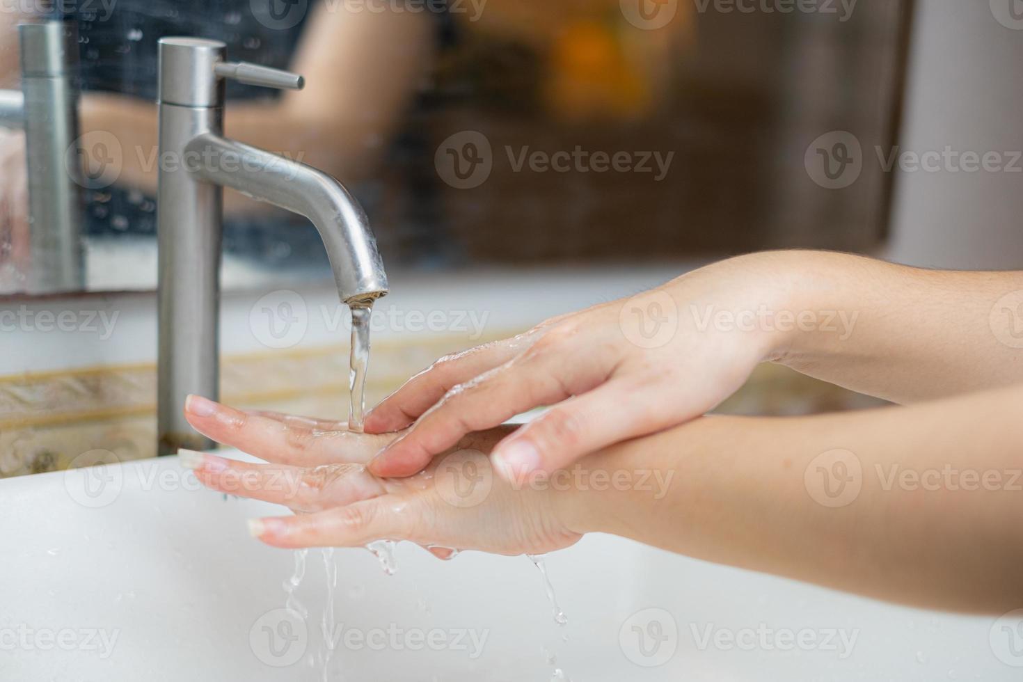 la hermosa mano femenina que aplica jabón en el fregadero o anti-bacterias para evitar la propagación de gérmenes en el fondo blanco foto