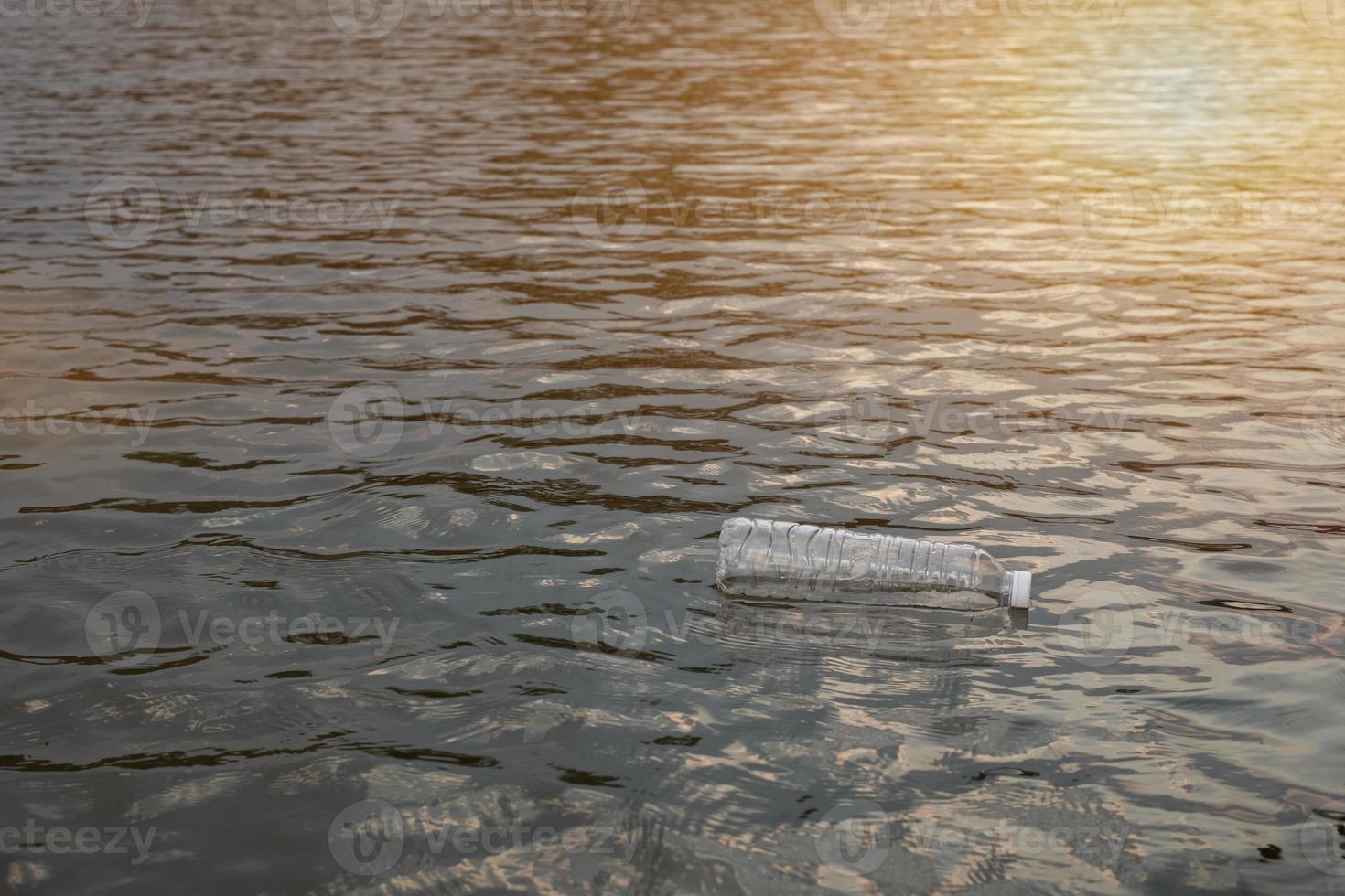 Used waste plastic bottle floating on water in a canal, Eco-friendly approach Environmental and Pollution Concept photo