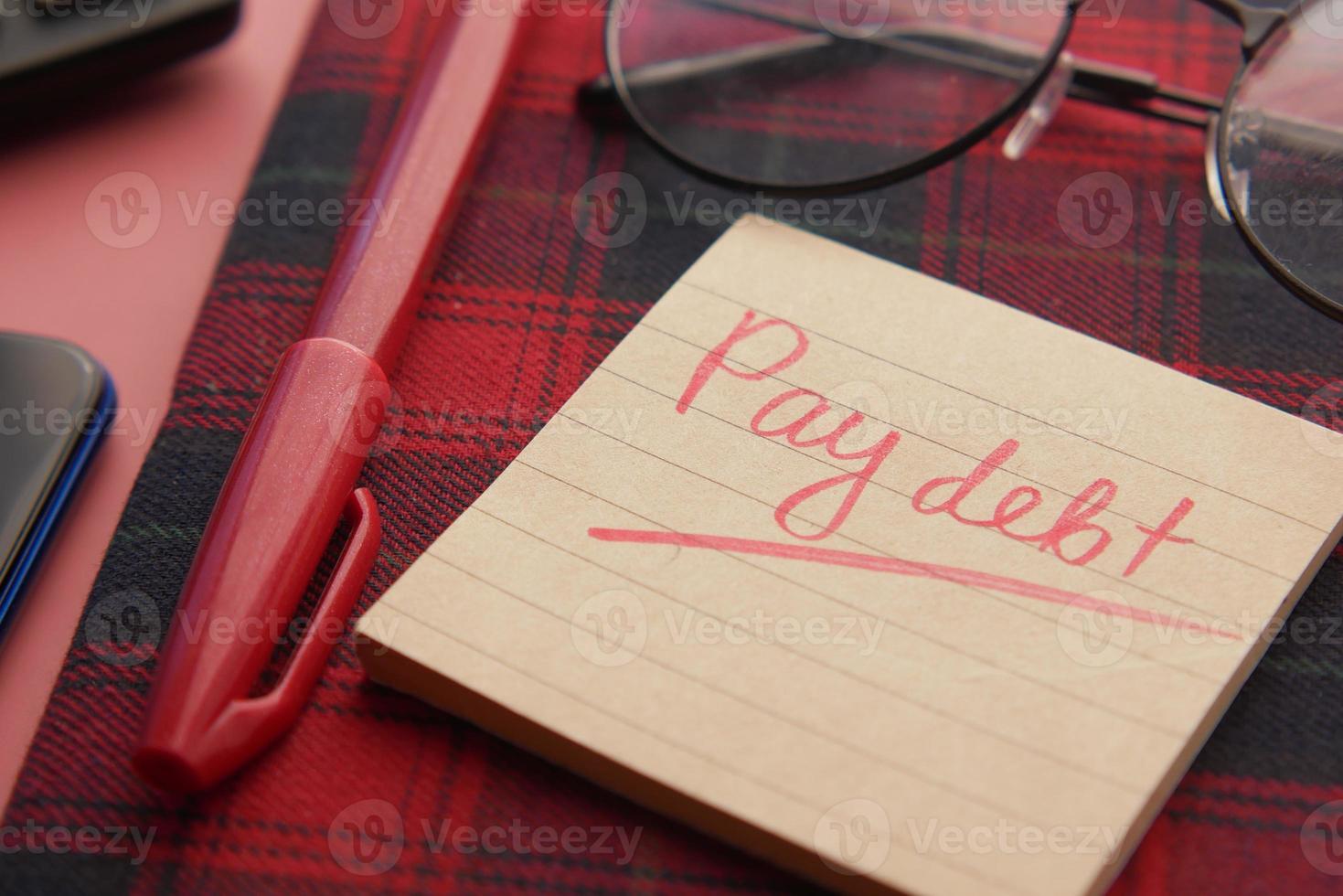 Close up of pay debt word on a sticky note photo