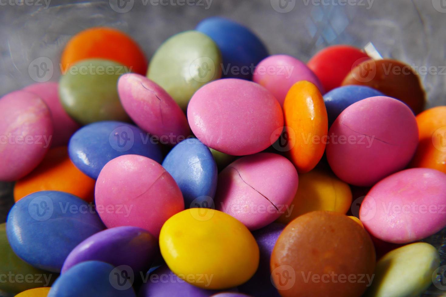 Caramelos dulces multicolores en un recipiente de cerca foto