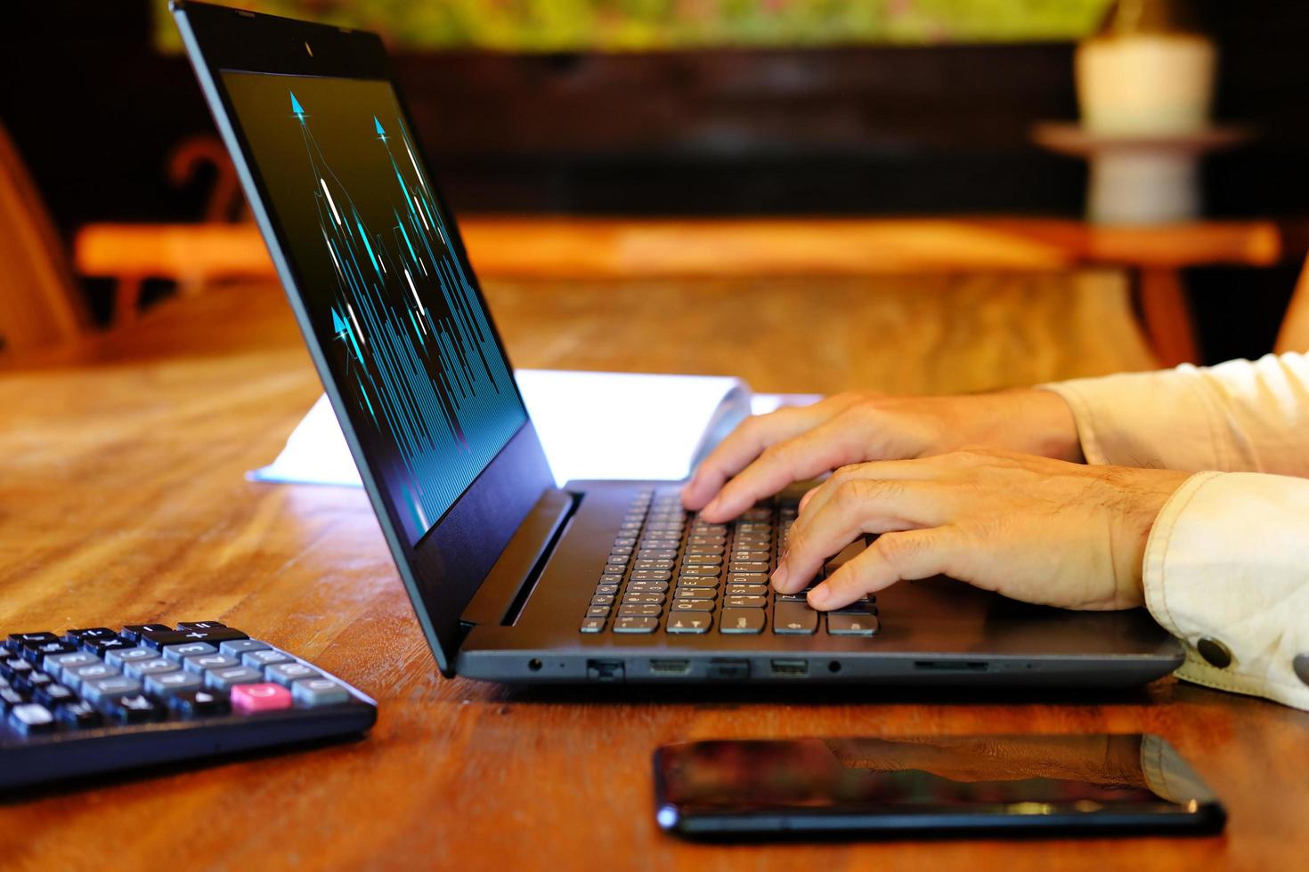 businessman works on his laptop, analyzing banking and investment growth graphs in order to make wise financial decisions for his business plan approach, as well as analyzing forex trading graphs. photo