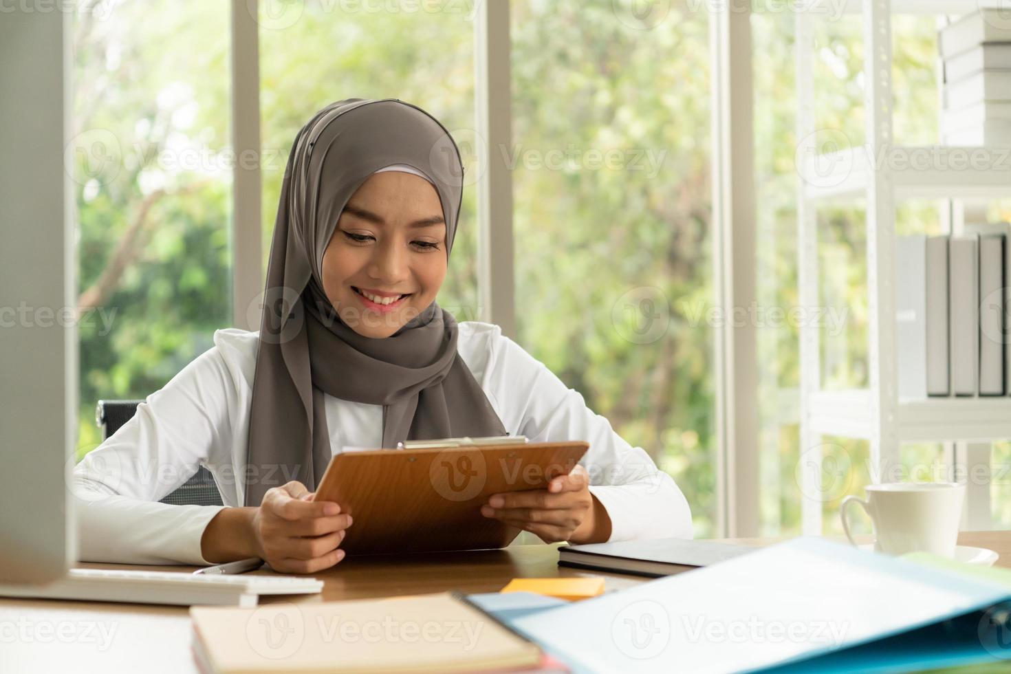 La empresaria árabe vistiendo hijab trabaja en la oficina. foto