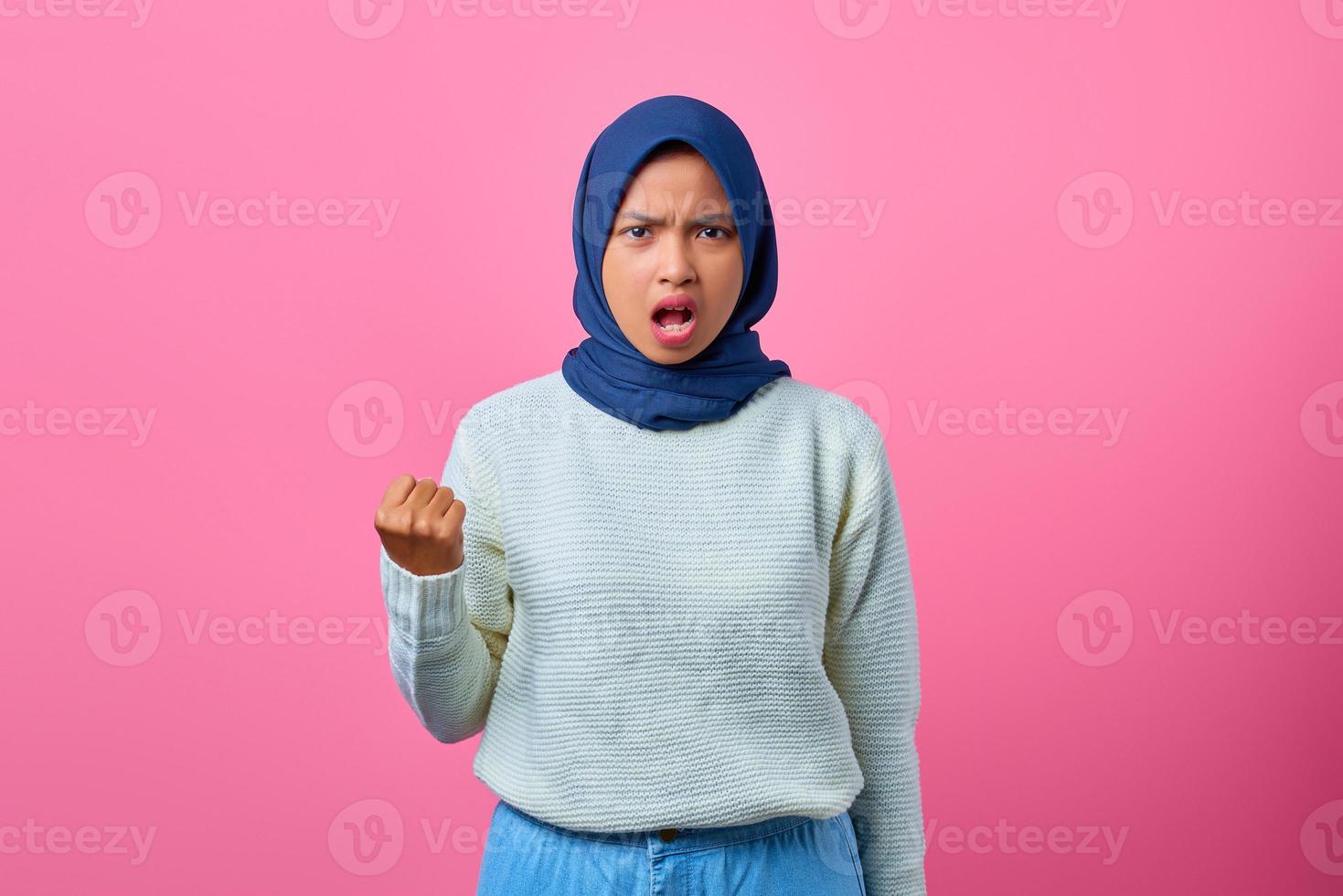 Retrato de hermosa mujer asiática con la mano levantada con expresión enojada foto