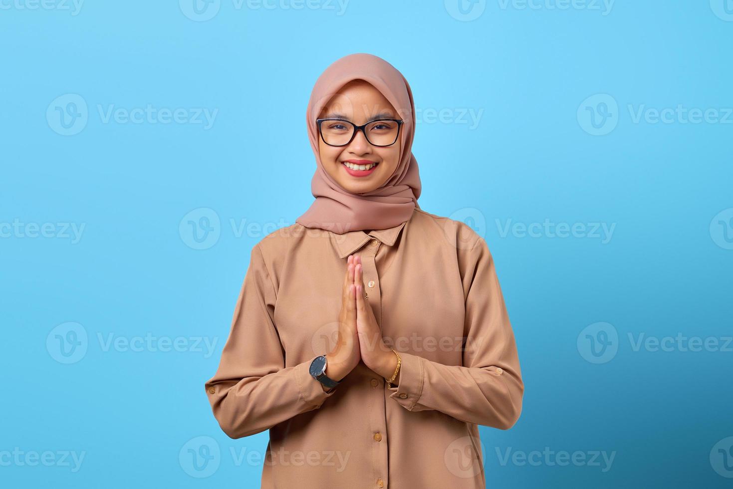 Portrait of happiness young Asian woman holding hand on plead over blue background photo