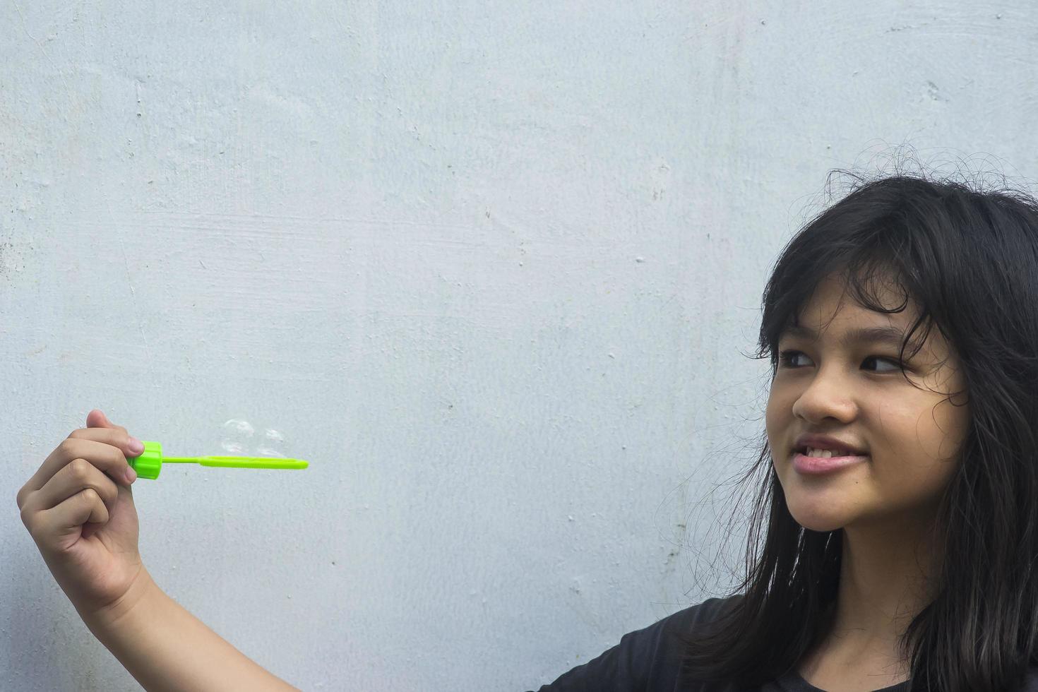 A girl holding a bubble maker and blowing them out. photo