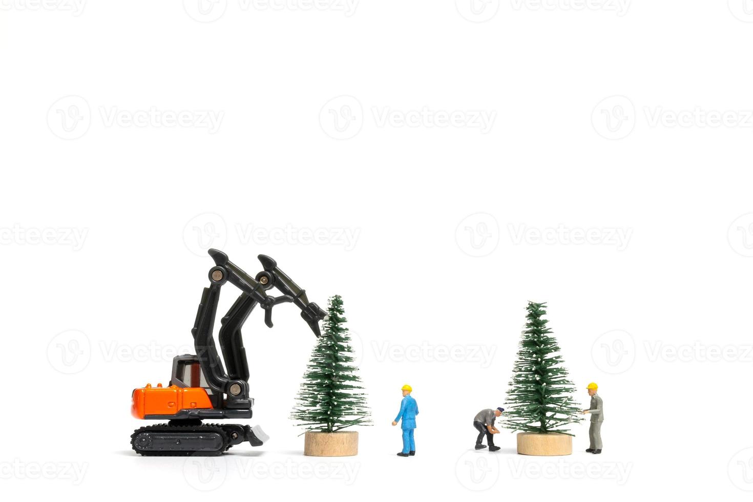 Gente en miniatura, trabajador preparando el árbol de navidad sobre fondo blanco. foto