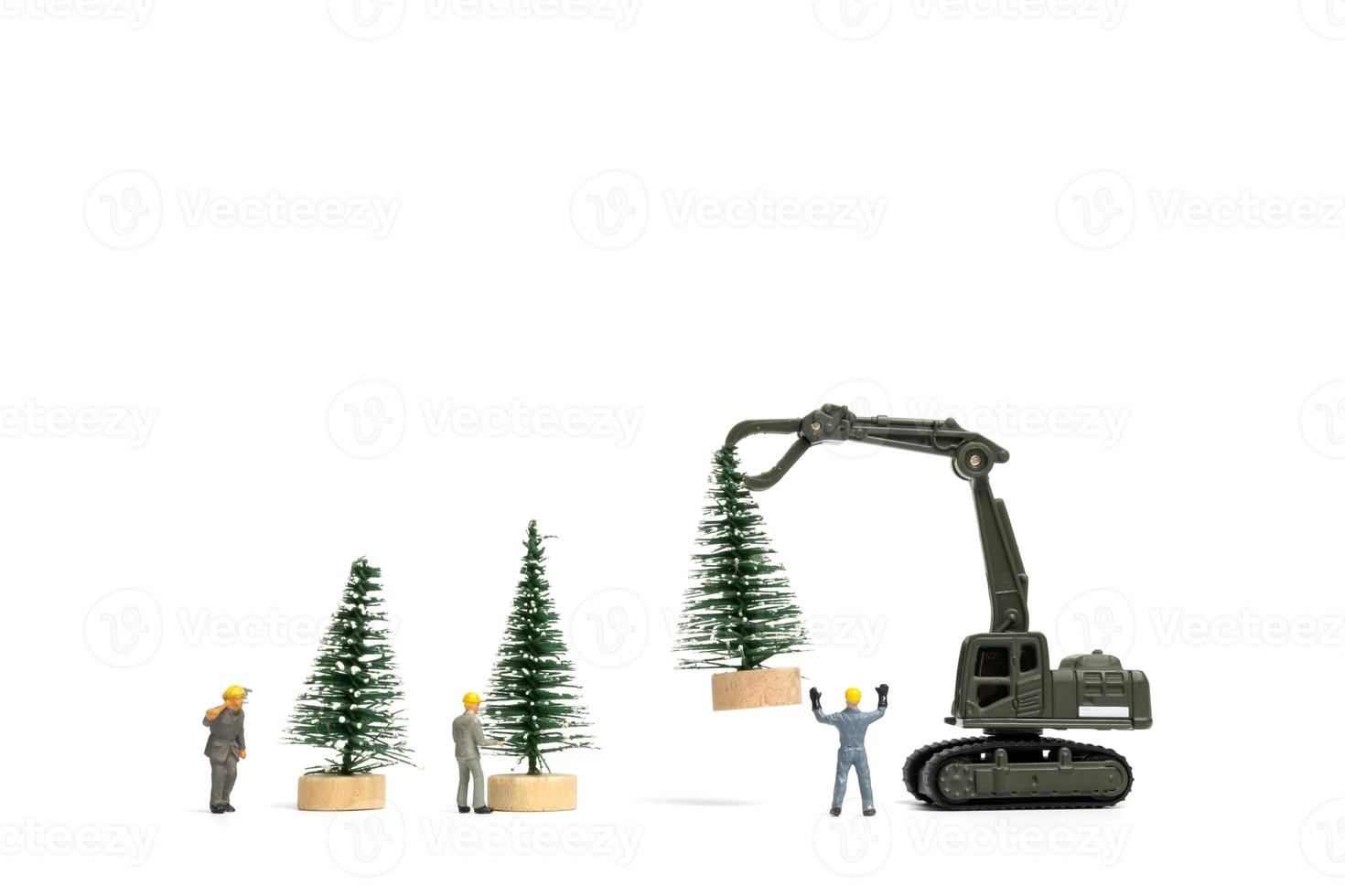 Gente en miniatura, trabajador preparando el árbol de navidad sobre fondo blanco. foto
