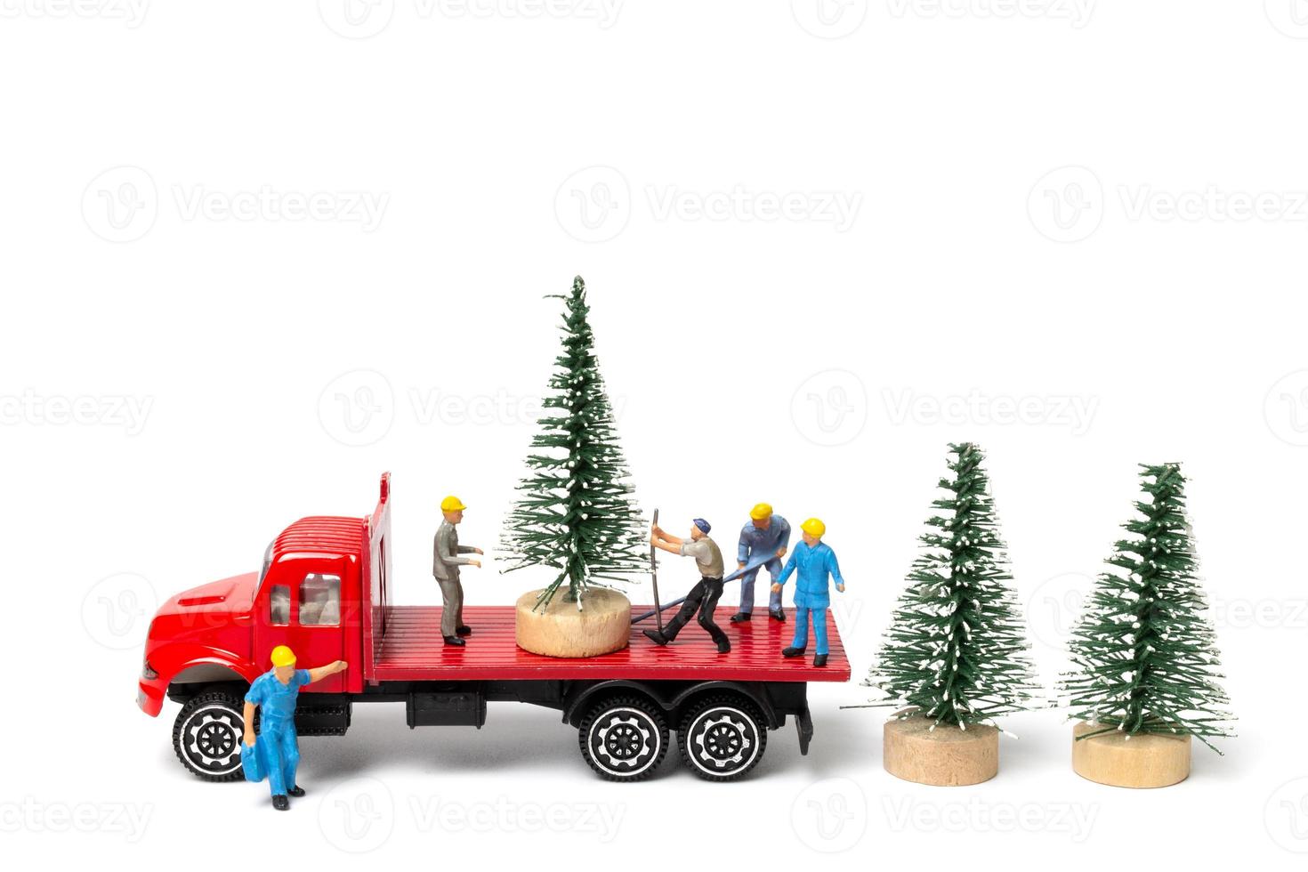 Gente en miniatura, trabajador preparando el árbol de navidad sobre fondo blanco. foto