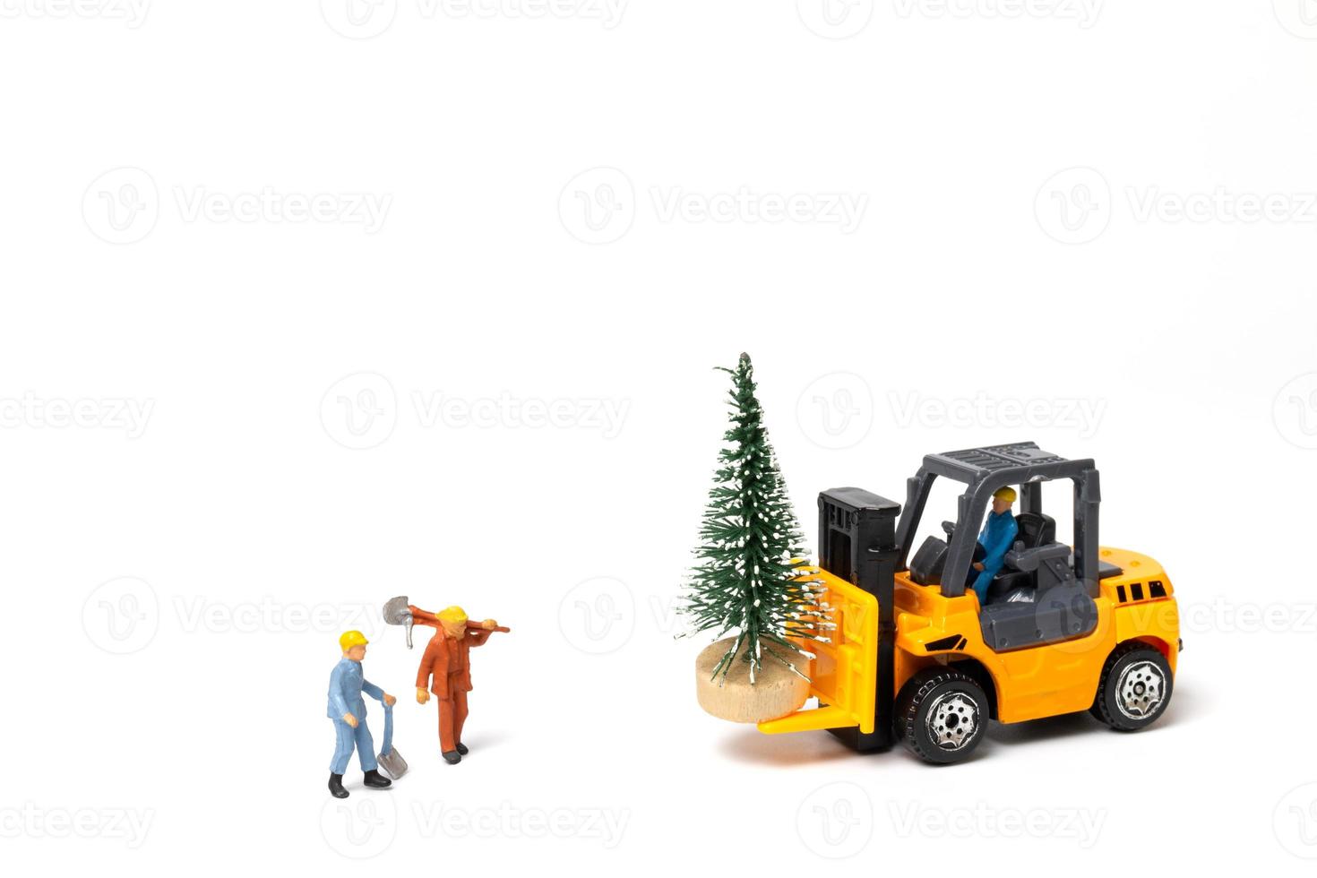 Gente en miniatura, trabajador preparando el árbol de navidad sobre fondo blanco. foto