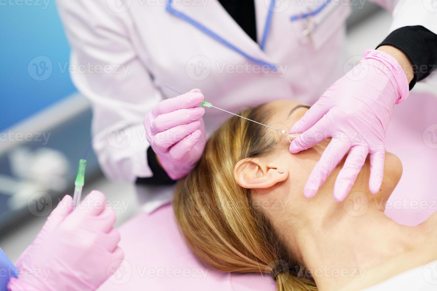 médico inyectando hilos de tratamiento de sutura pdo en el rostro de una mujer. foto