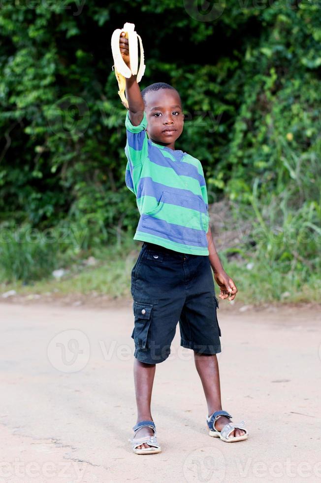 child showing a banana half eaten. photo