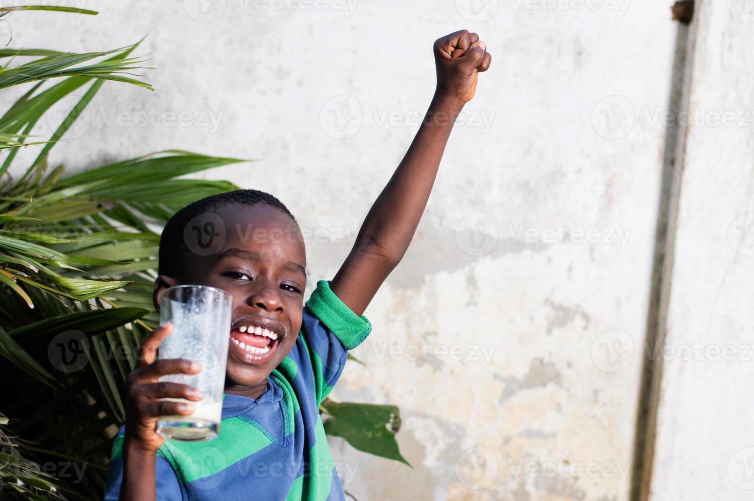 niño feliz sosteniendo un vaso de leche. foto