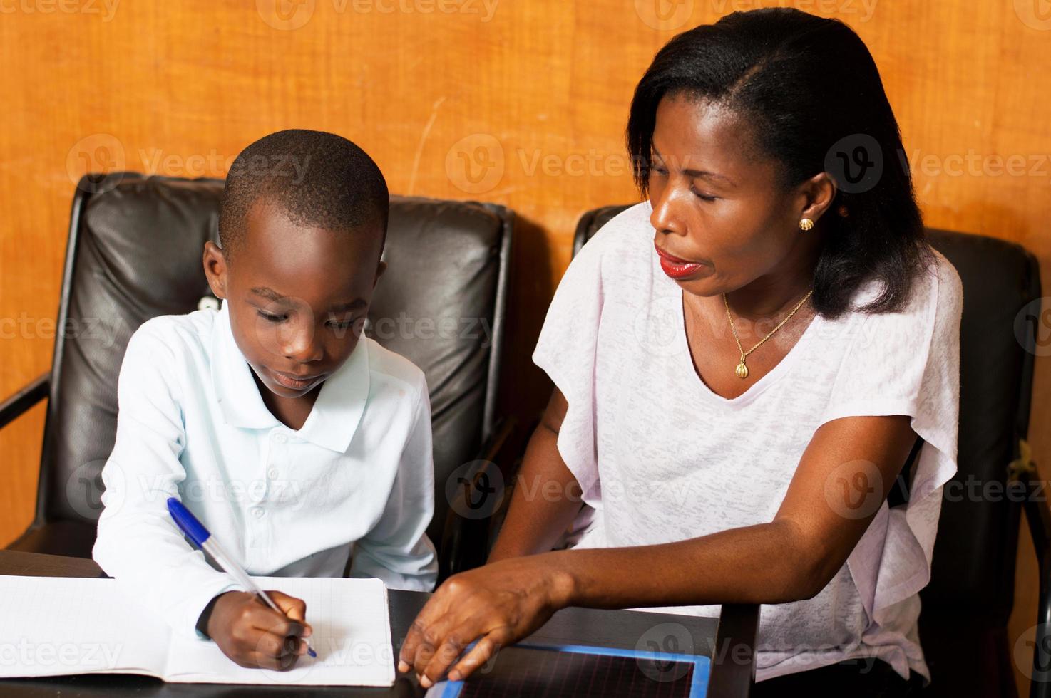 niño estudiante con su madre en casa. foto