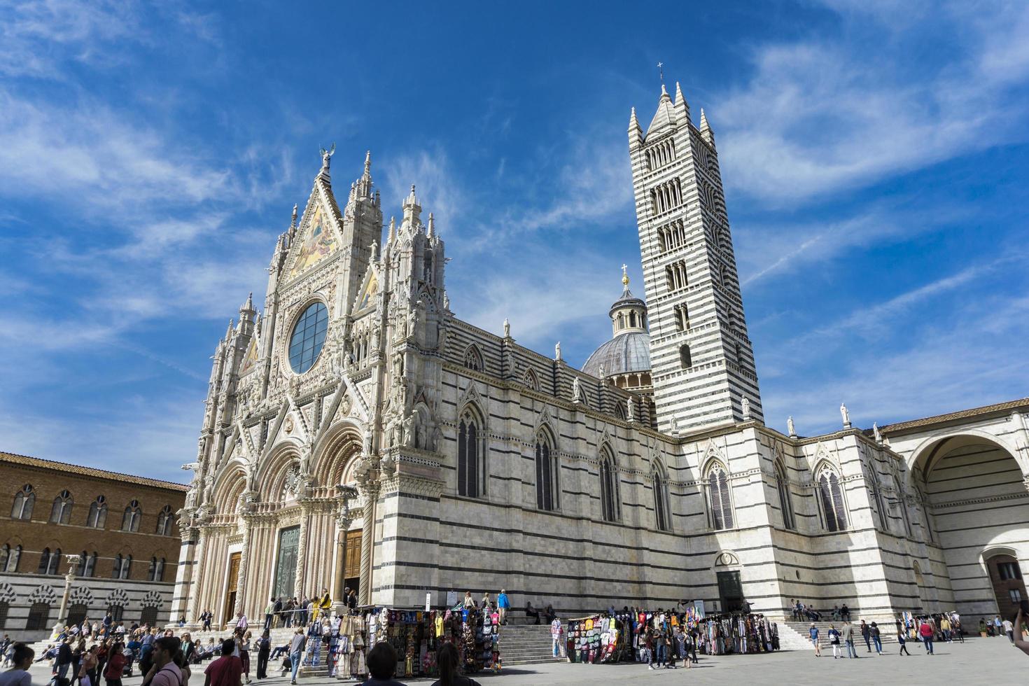 SIENA, ITALY, APRIL 8, 2018 - Unidentified people in front of the Siena Cathedral, Italy. It is a medieval Roman Catholic Marian church now dedicated to the Assumption of Mary. photo