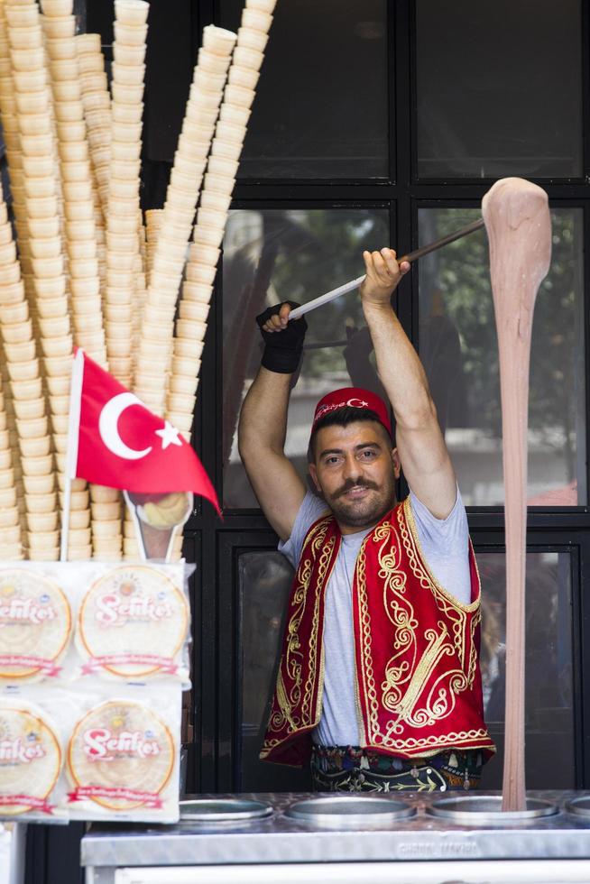 ISTANBUL, TURKEY, JUNE 15, 2019 - Unidentified seller of Turkish ice cream at Istanbul, Turkey. Traditional Turkish ice cream was made with salep, produced by orchid flowers. photo