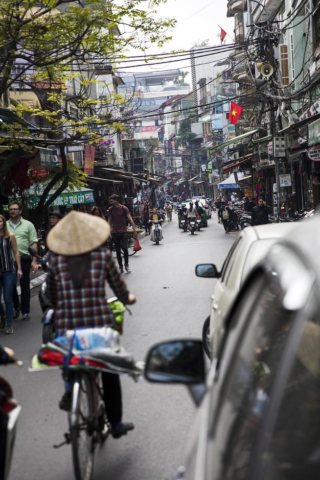 HANOI, VIETNAM, MARCH 2, 2017 - Unidentified people on the street of Hanoi, Vietnam. At Hanoi, motorbikes have overtaken bicycles as the main form of transportation. photo