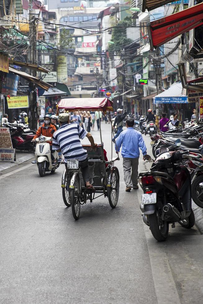 HANOI, VIETNAM, MARCH 2, 2017 - Unidentified people on the street of Hanoi, Vietnam. At Hanoi, motorbikes have overtaken bicycles as the main form of transportation. photo