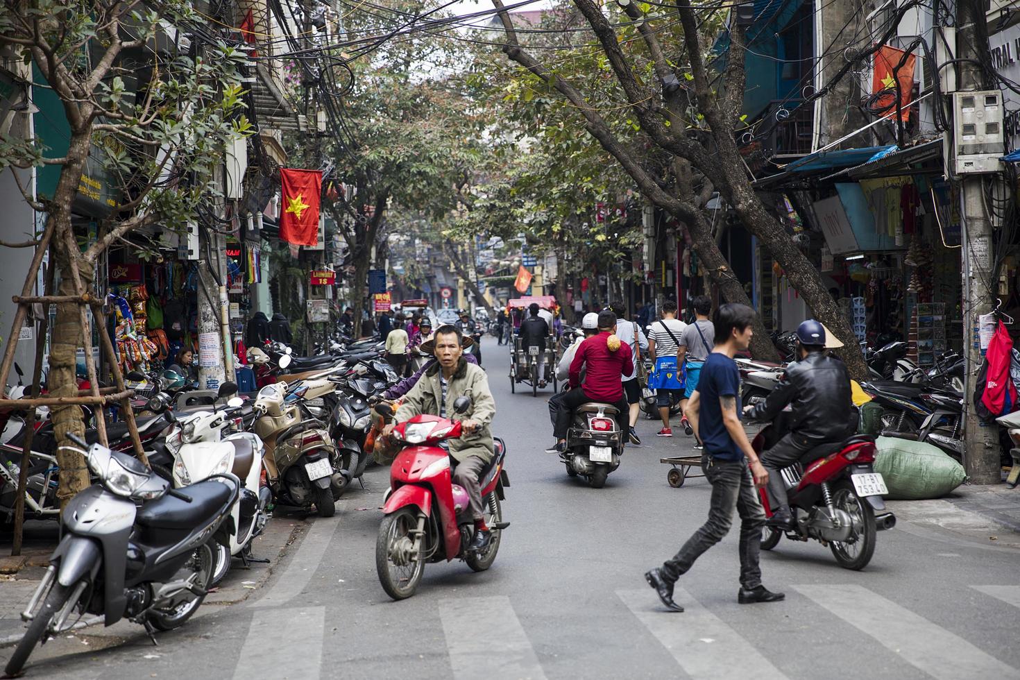 HANOI, VIETNAM, MARCH 2, 2017 - Unidentified people on the street of Hanoi, Vietnam. At Hanoi, motorbikes have overtaken bicycles as the main form of transportation. photo
