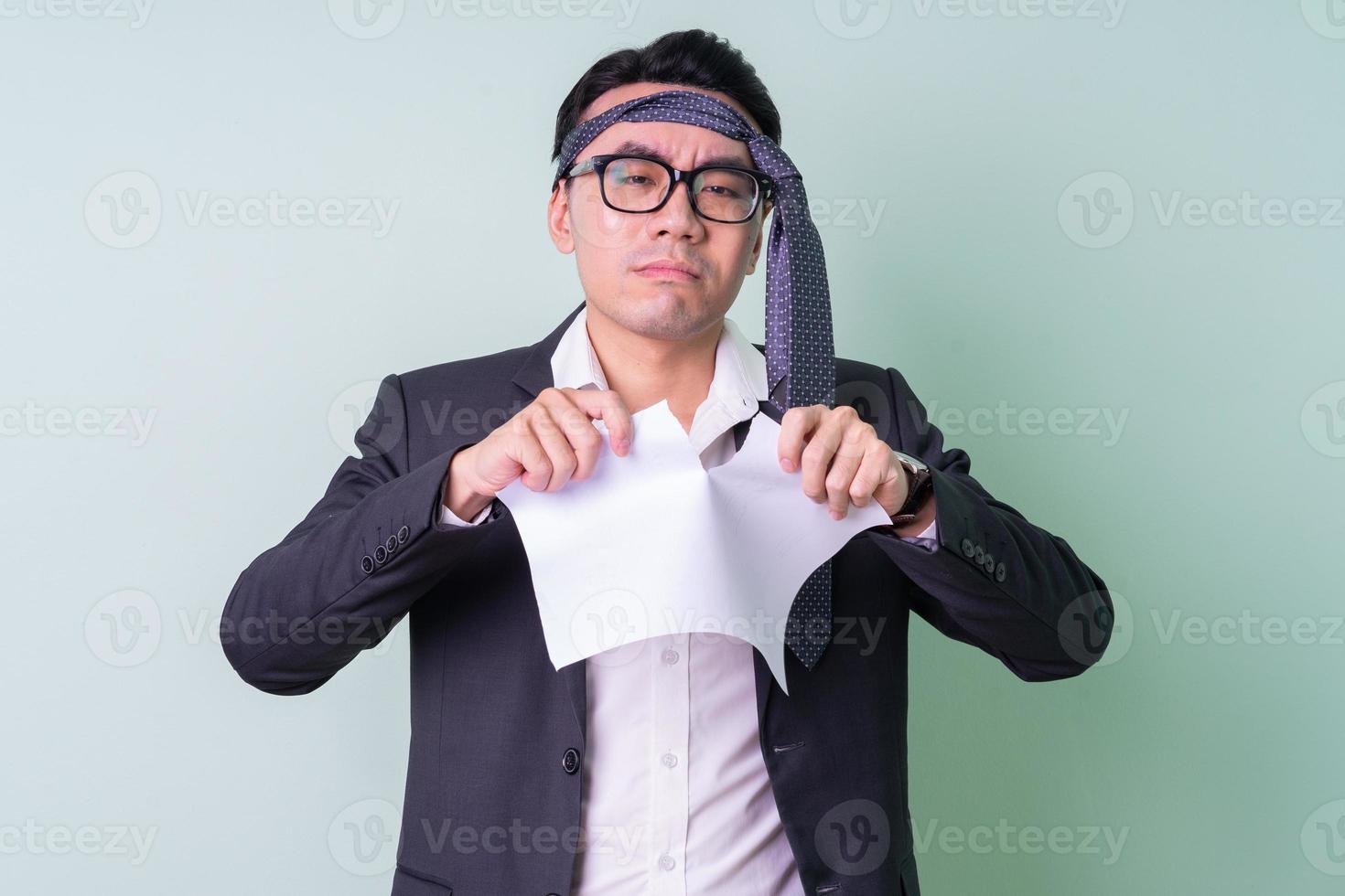 Young Asian businessman posing on green background photo