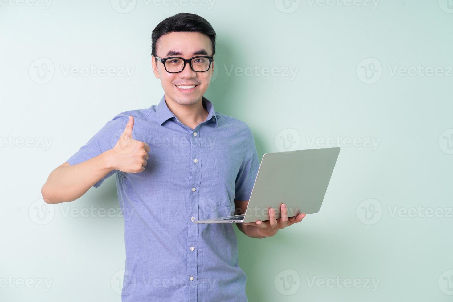 joven empresario asiático posando sobre fondo verde foto