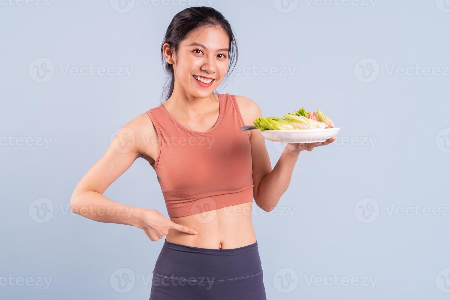 Hermosa mujer asiática vistiendo ropa deportiva y haciendo yoga, fitness y concepto de gimnasio foto