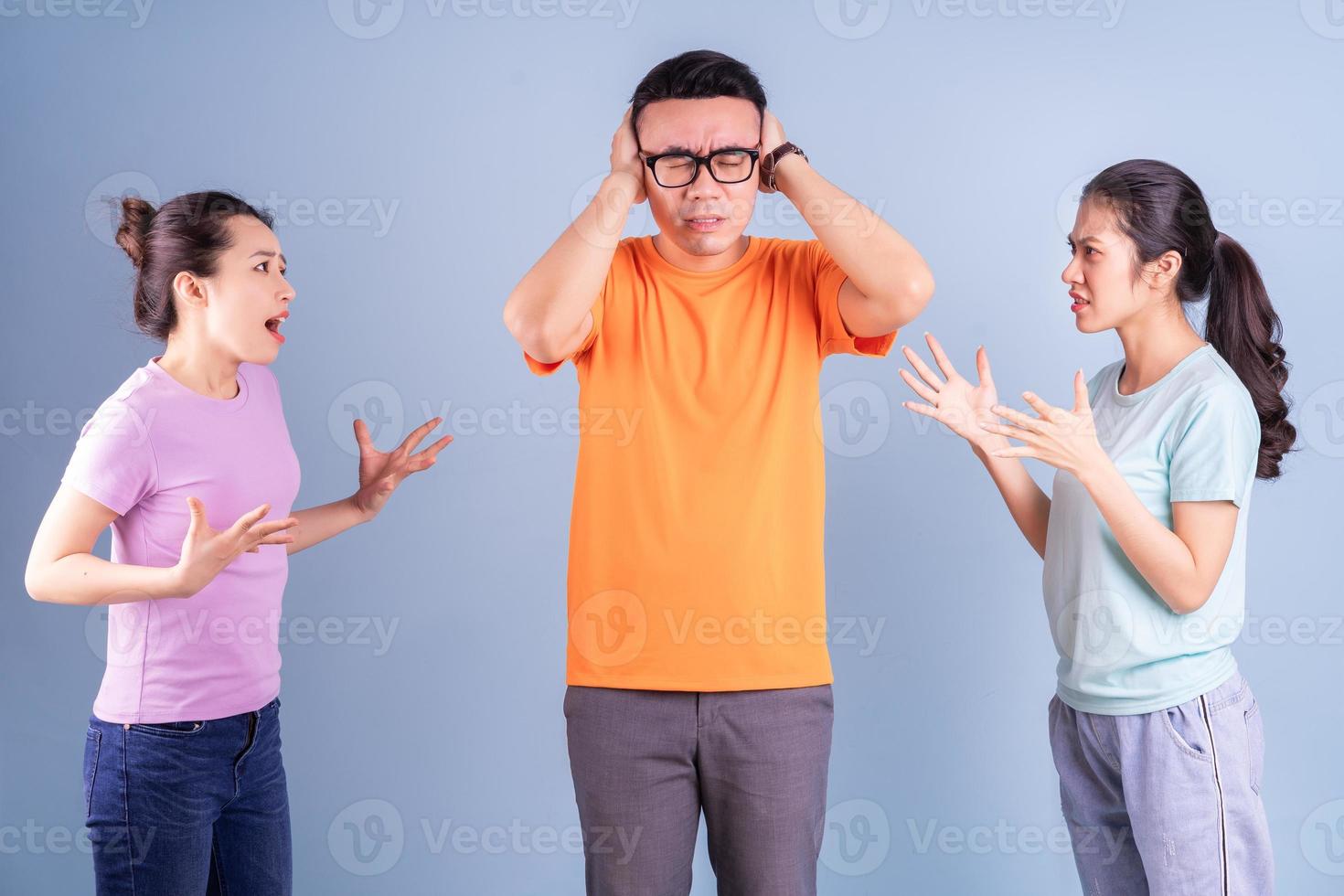 Three young Asian people posing on blue background photo