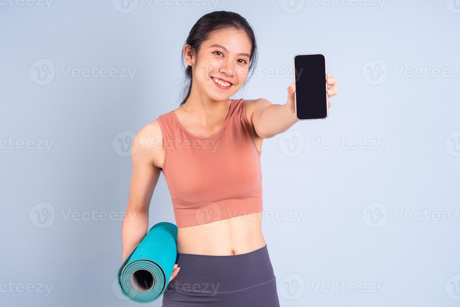 Beautiful Asian woman wearing sportswear and doing yoga, fitness and gym concept photo