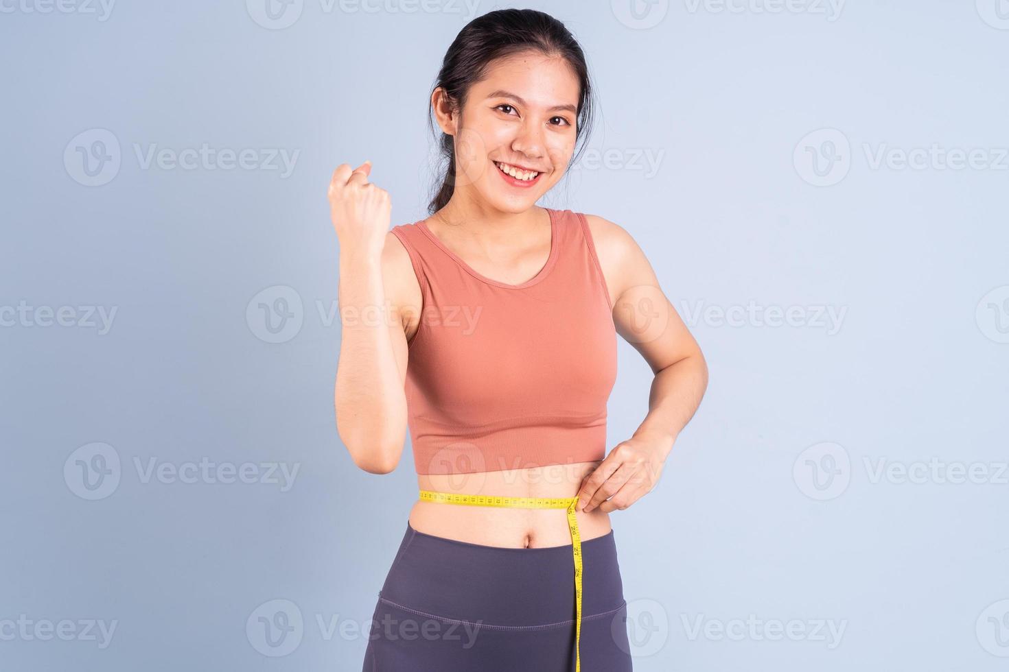 Hermosa mujer asiática vistiendo ropa deportiva y haciendo yoga, fitness y concepto de gimnasio foto