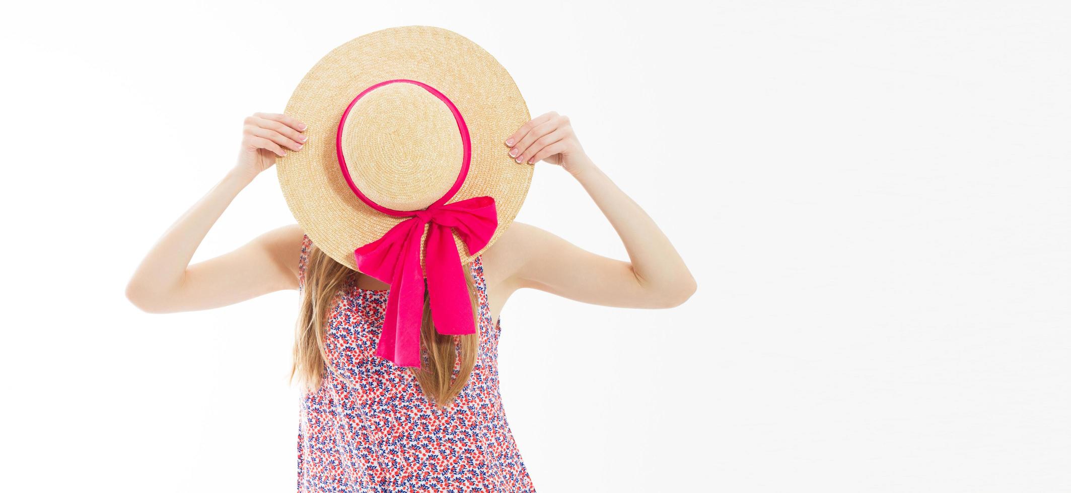 Beautiful slim girl hide her face behind a summer hat isolated on white background copy space. photo