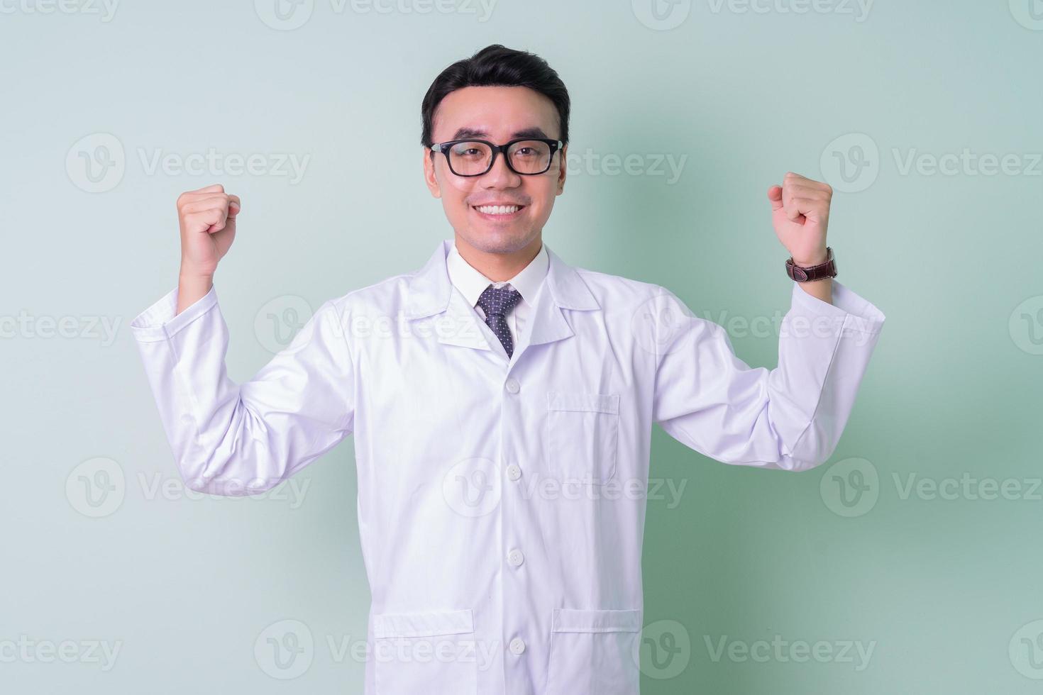 Asian doctor standing on green background photo