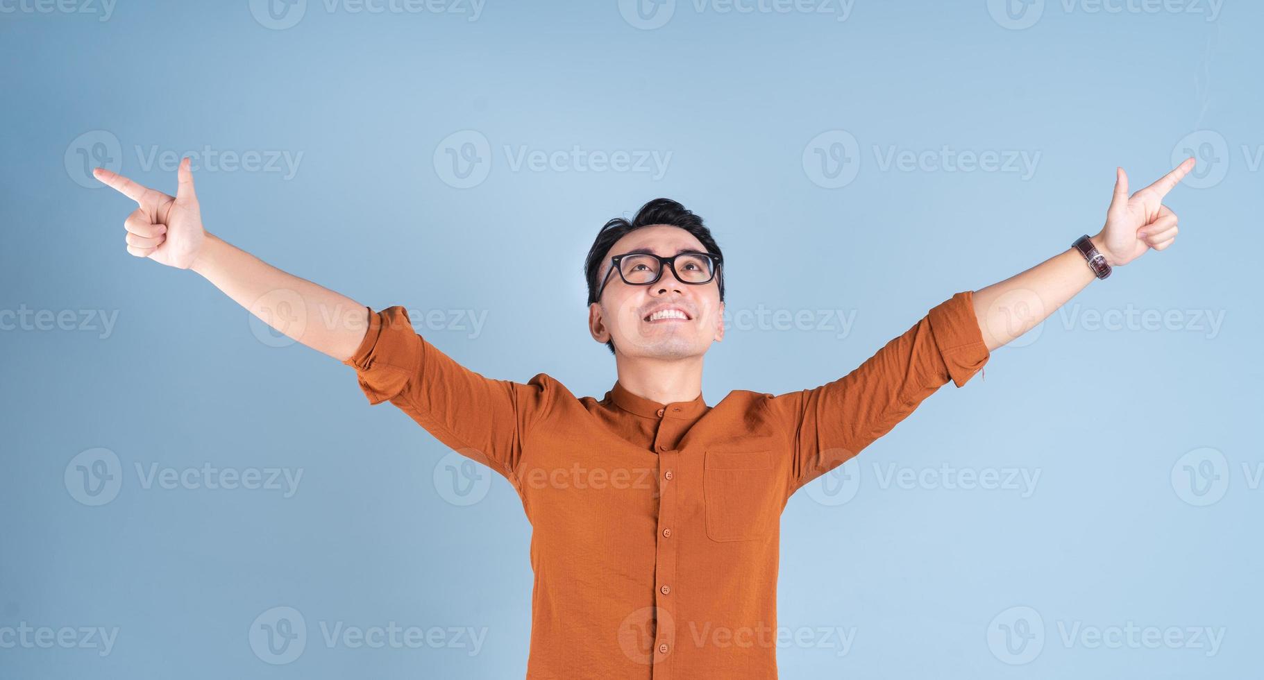 Young Asian businessman posing on blue background photo