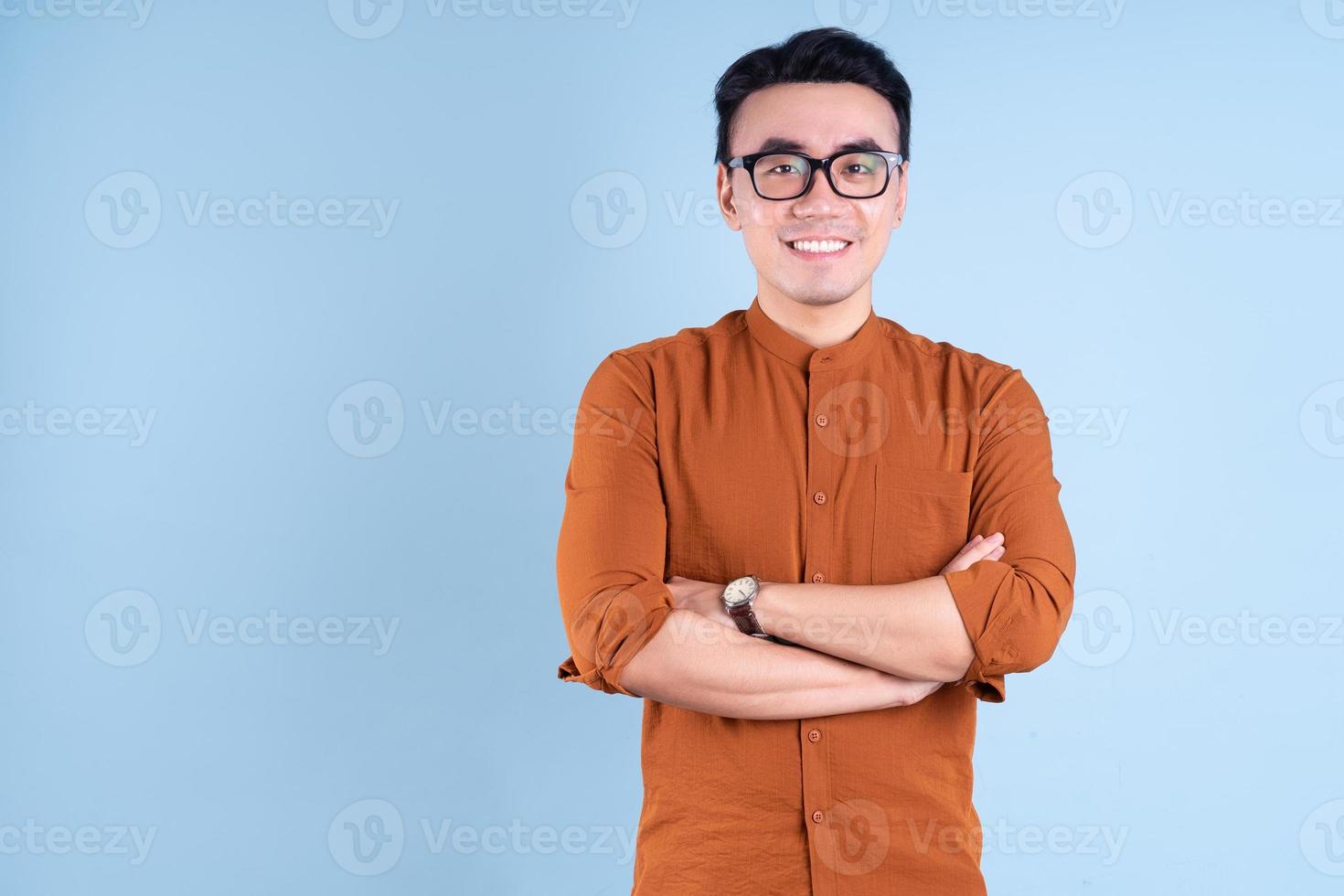 Young Asian businessman posing on blue background photo