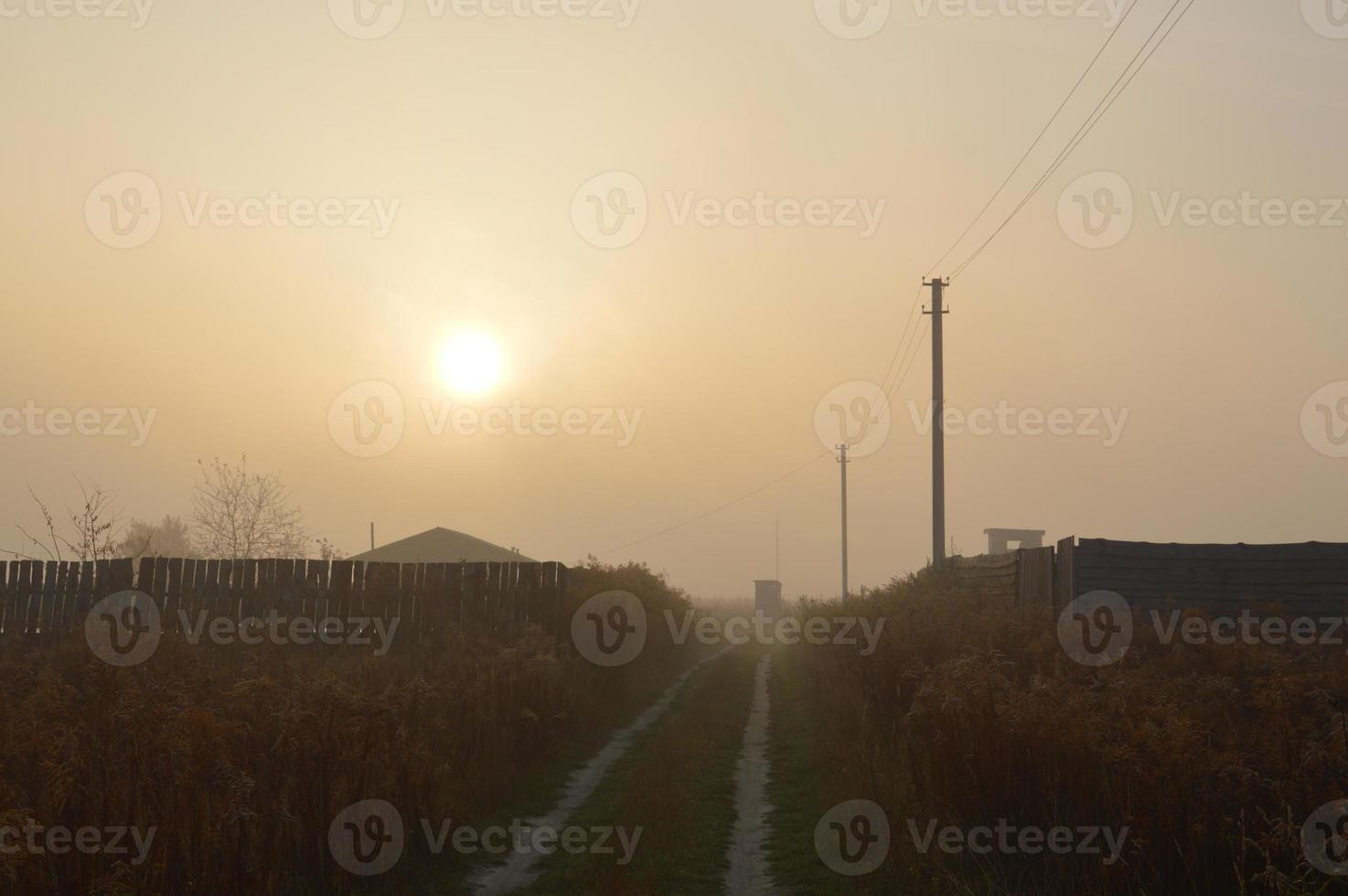 el sol de la mañana sale en el horizonte en el bosque y el pueblo foto