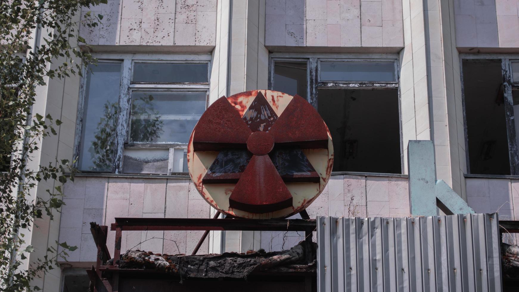 A radioactive abandoned  building overgrown with trees in the city of Pripyat photo