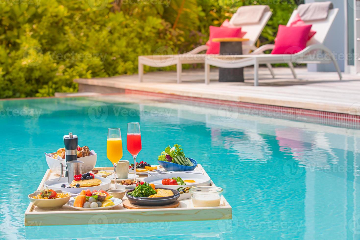 Breakfast in swimming pool, floating breakfast in luxurious tropical resort. Table relaxing on calm pool water, healthy breakfast fruit plate hotel resort pool. Tropical couple beach luxury lifestyle photo