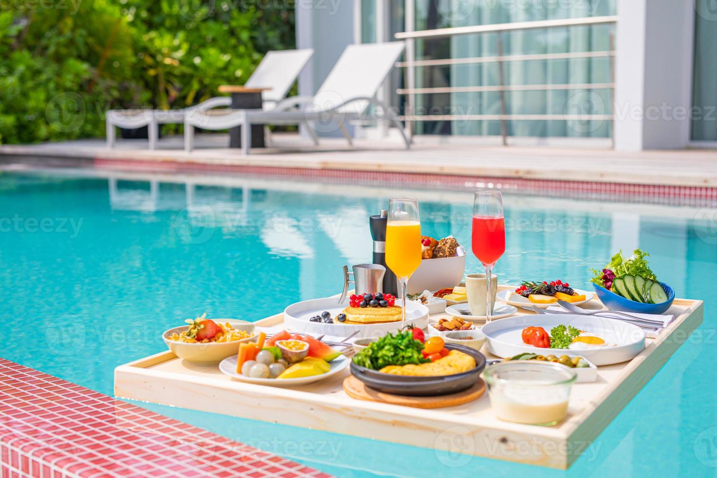desayuno en piscina, desayuno flotante en lujoso resort tropical. mesa relajante en el agua tranquila de la piscina, desayuno saludable plato de frutas hotel resort piscina. pareja tropical playa estilo de vida de lujo foto