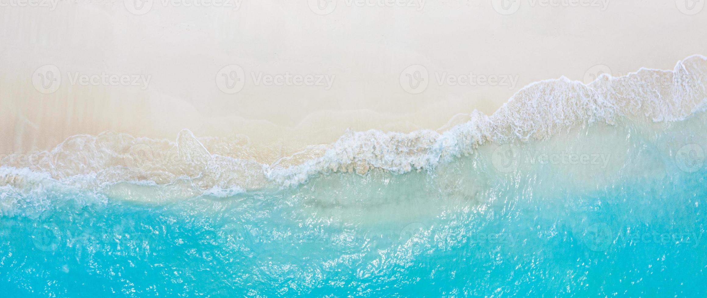 Summer seascape beautiful waves, blue sea water in sunny day. Top view from drone. Sea aerial view, amazing tropical nature background. Beautiful bright sea with waves splashing and beach sand concept photo