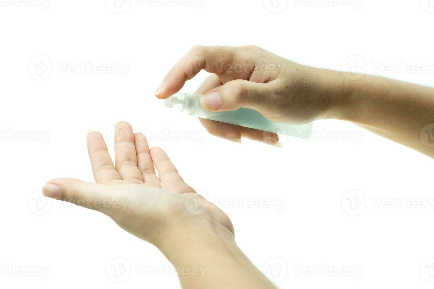 Mano de mujer que aplica spray de alcohol de la botella de plástico o anti bacterias para evitar la propagación de gérmenes en el fondo blanco. foto