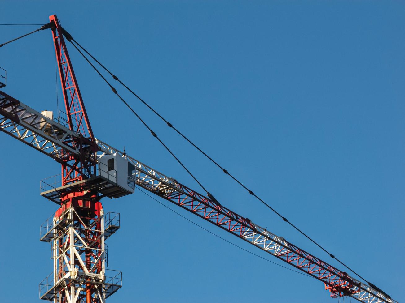 Modern construction crane against cloudy sky background. photo