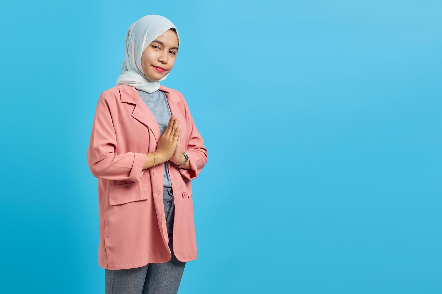 Portrait of beautiful asian woman smiling with a friendly expression over blue background photo