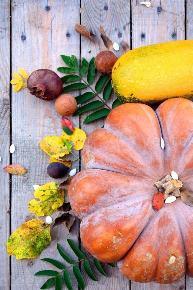 Pumpkin with autumn leaves on a wooden background. Natural background with pumpkins for Halloween. photo