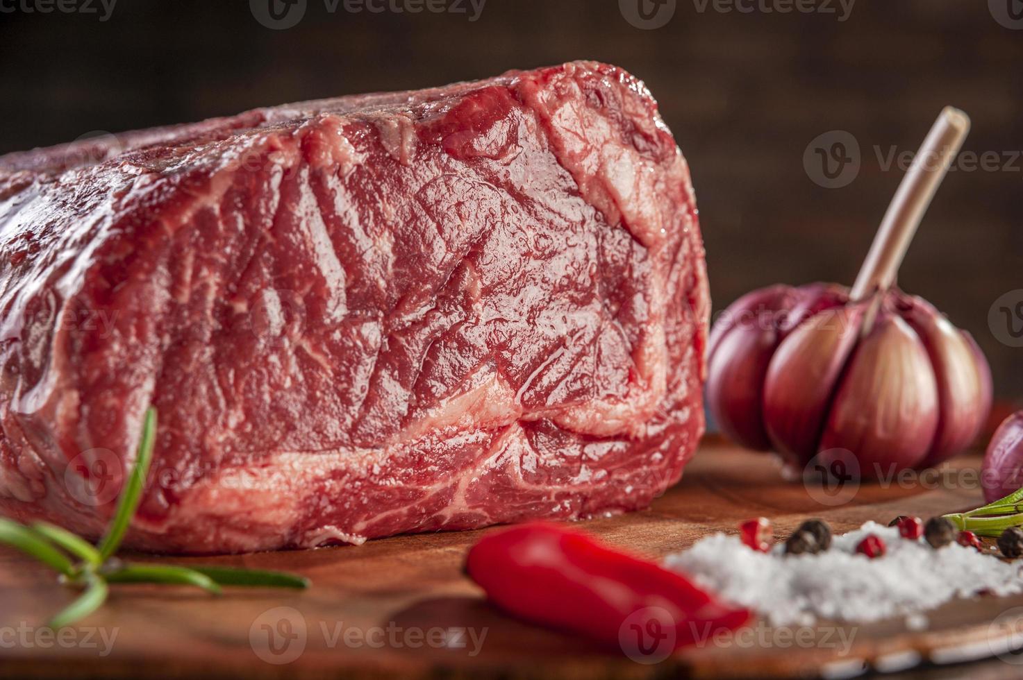 Raw entrecote beef on a wood cutting board with spices - Closeup. photo