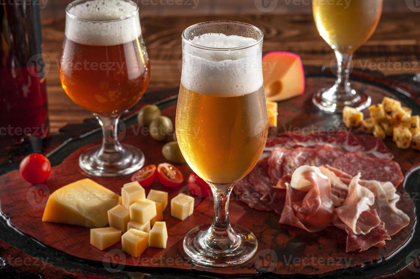 Plato frío con cerveza de barril sobre una tabla para cortar madera foto